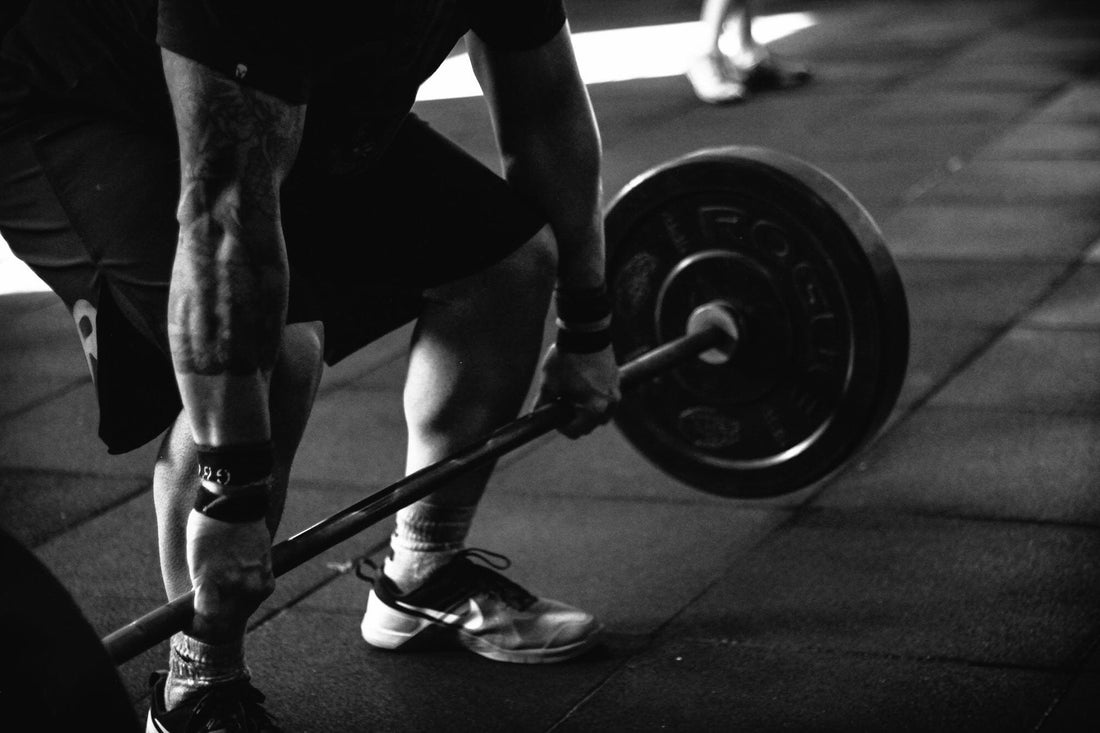 Close-up of an athlete performing a deadlift in the gym, representing strength and power development for boxing and weight training.