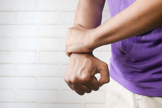 Person holding their wrist in pain, illustrating how cheap boxing gloves cause injury and highlighting the importance of boxing gloves injury prevention during training.