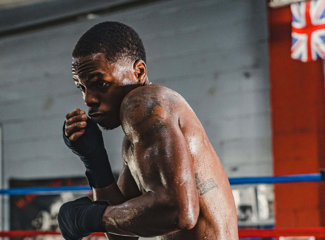 Focused boxer training in the gym, highlighting how to choose boxing gloves for your training style and performance needs