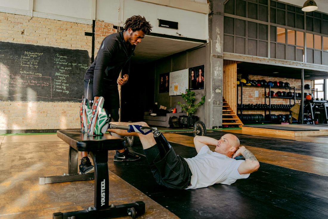 Boxer performing core exercises with a trainer in a gym, focusing on ab strength and stability for boxing performance.