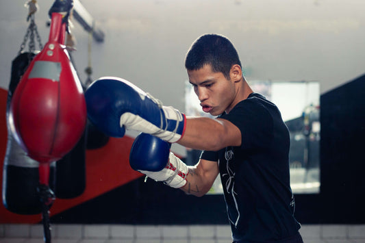 Boxer training with a double-end bag in a gym, demonstrating focus, technique, and the atmosphere of a good boxing gym.
