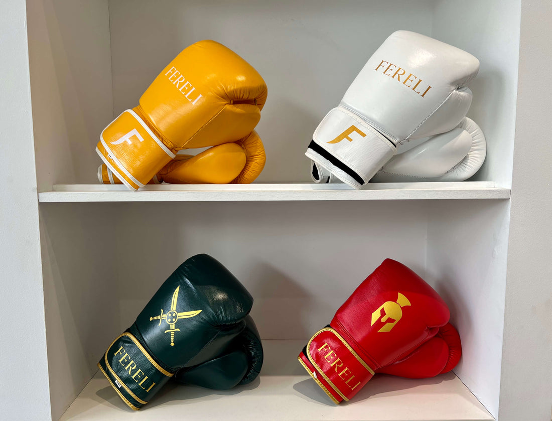 four pairs of Fereli boxing gloves in yellow, white, green and red displayed on shelves for training use