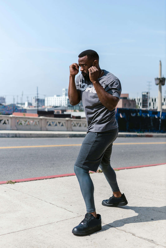 Man practicing shadowboxing outdoors, focusing on rhythm, stance, and movement to improve boxing technique.