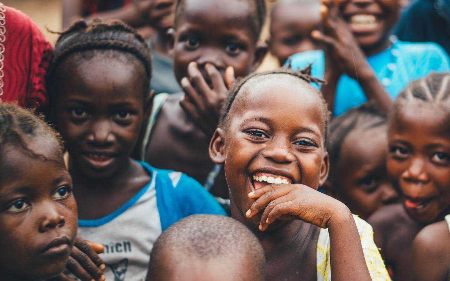 Children smiling in a local community supported through Fereli Cares’ commitment to global humanitarian and youth-focused initiatives.