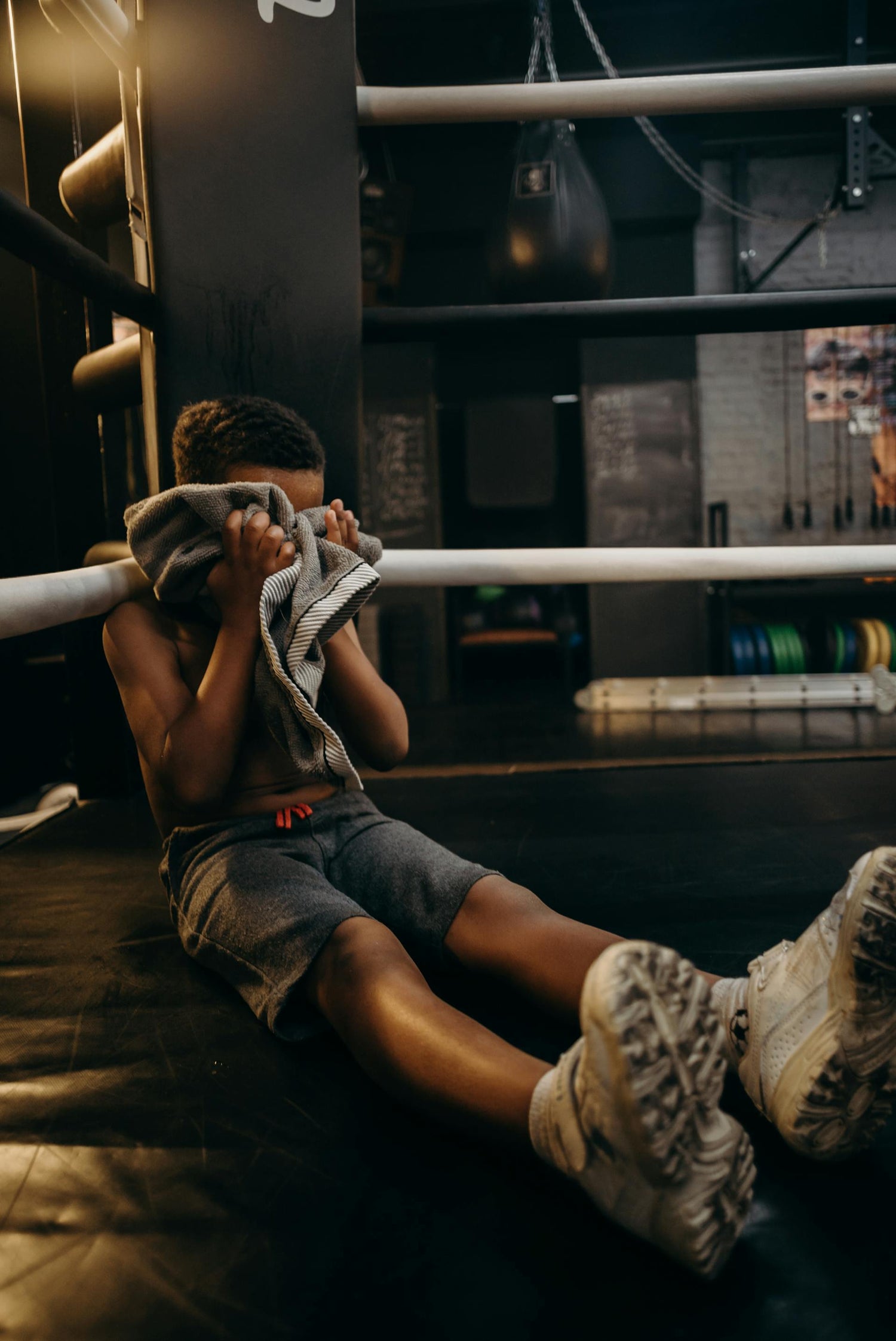 Young boxer resting in the ring after an intense session—capturing the discipline and quiet perseverance celebrated by the Fereli Code and essential to every future boxer champion.
